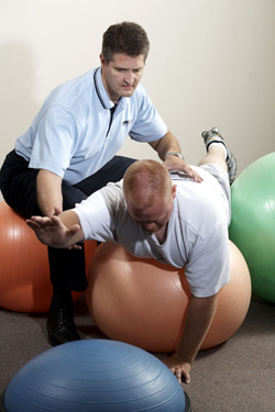Physical therapist works with client on exercise ball at PROCare in Greenfield Wisconsin
